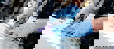 gloved hands sanding car bonnet