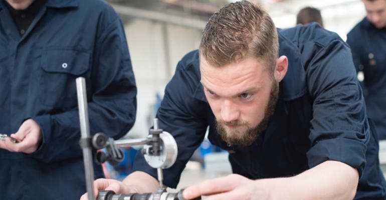 Apprentice looking at car part