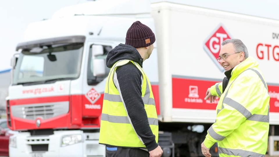 two men in hi-vis standing in front of GTG truck