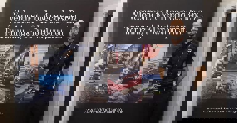 Mercedes trainer standing in front of Welcome to Mercedes-Benz Training and Development sign