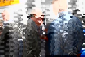 Prince Charles speaking to an apprentice next to car tyre