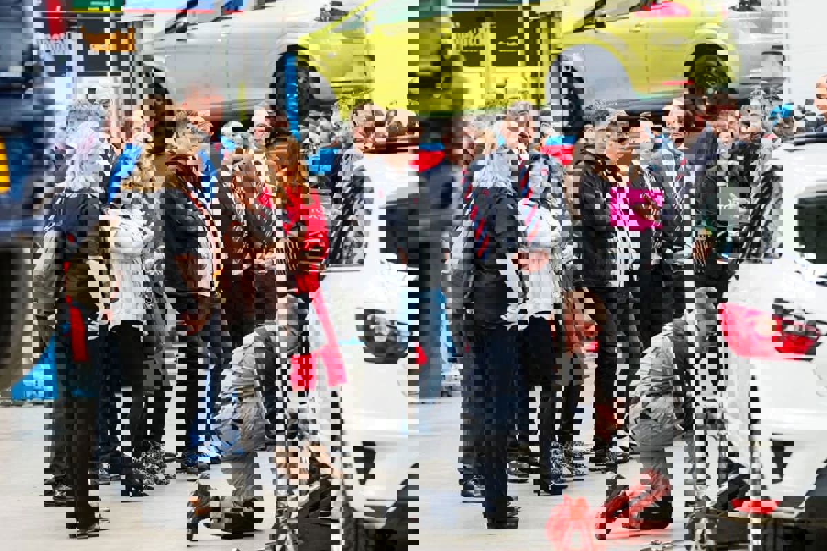 A group at a GTG open day watching and apprentice work on a car in the workshop