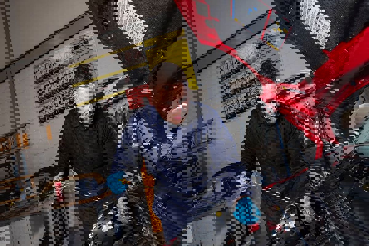 Apprentice checking the engine oil in a car