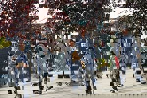 Four apprentices walking in front of GTG building with their certificates