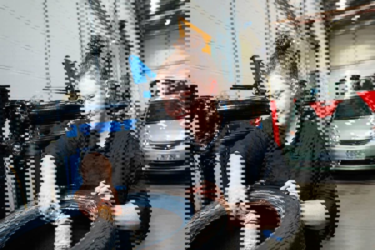 female apprentice checking a tyre