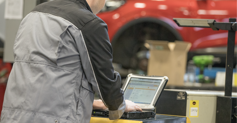 Technician looking at laptop running an MOT