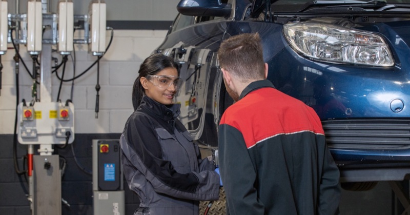 Technician and supervisor working on vehicle